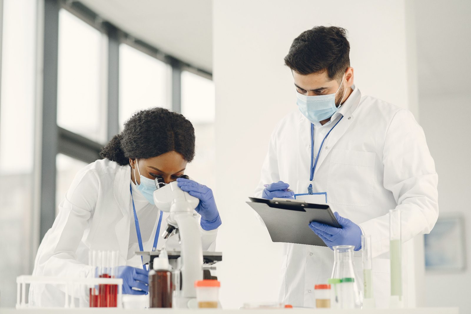 Clinical researchers analyzing trial samples in a laboratory; patient access to new treatment options through clinical trials